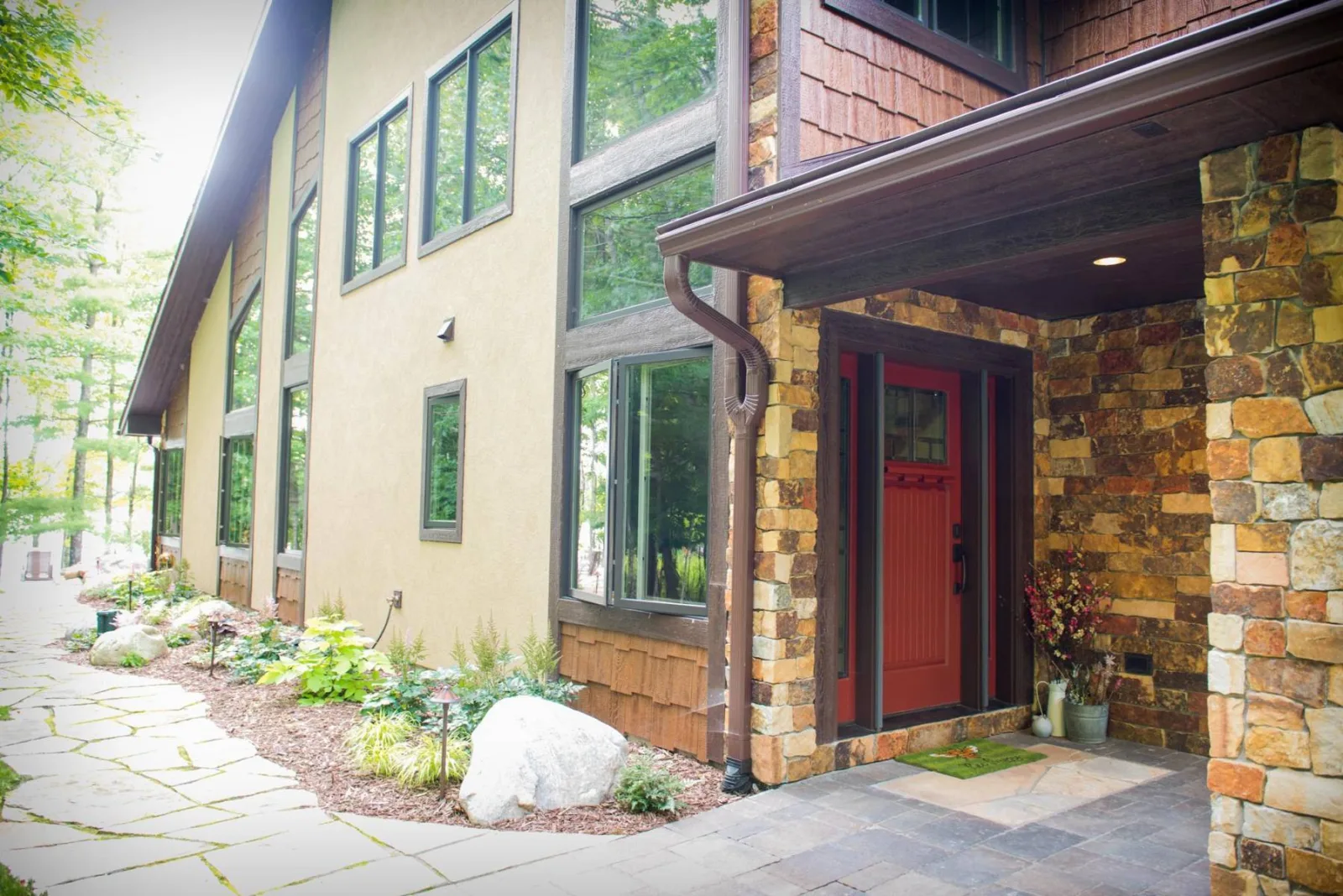 Stone and siding around a home's red entry door, from Keenan's own gallery