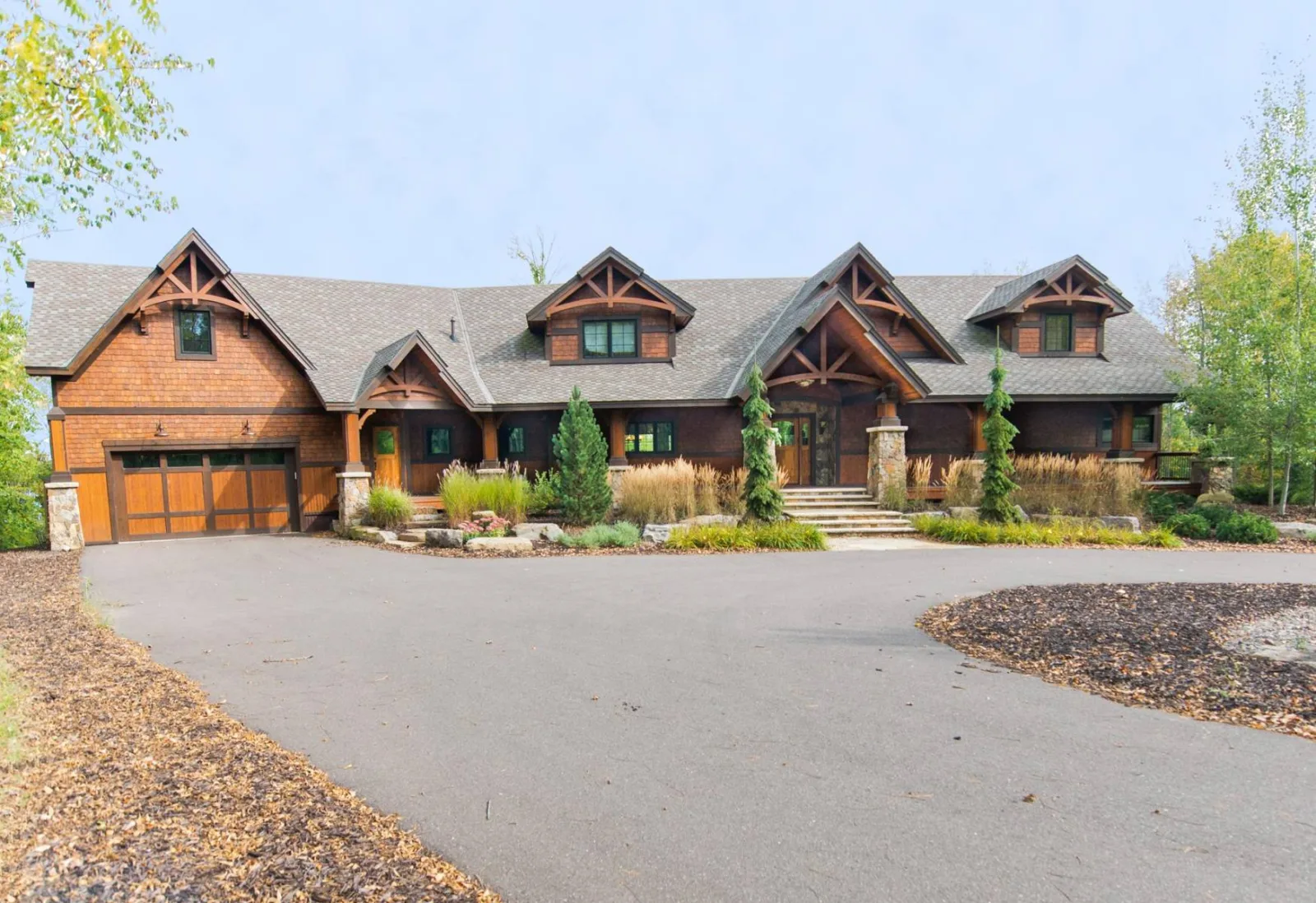 Timber-accented custom home exterior with a covered entry and attached garage, from Keenan's gallery