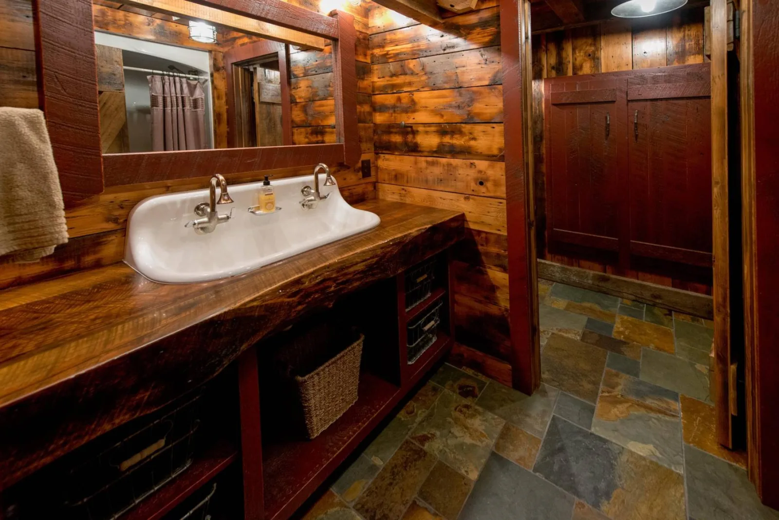 Wood-paneled bathroom with a stone shower and white basin, from Keenan's gallery